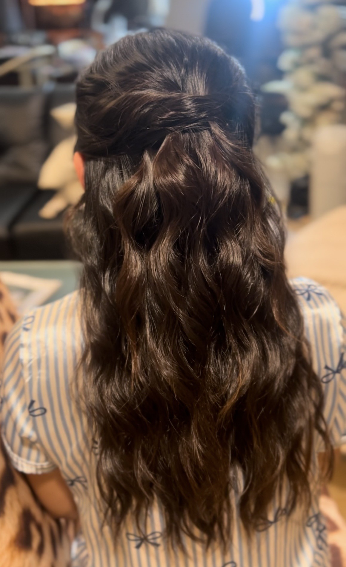 Half-up bridal style with a twisted crown and long loose waves through the ends